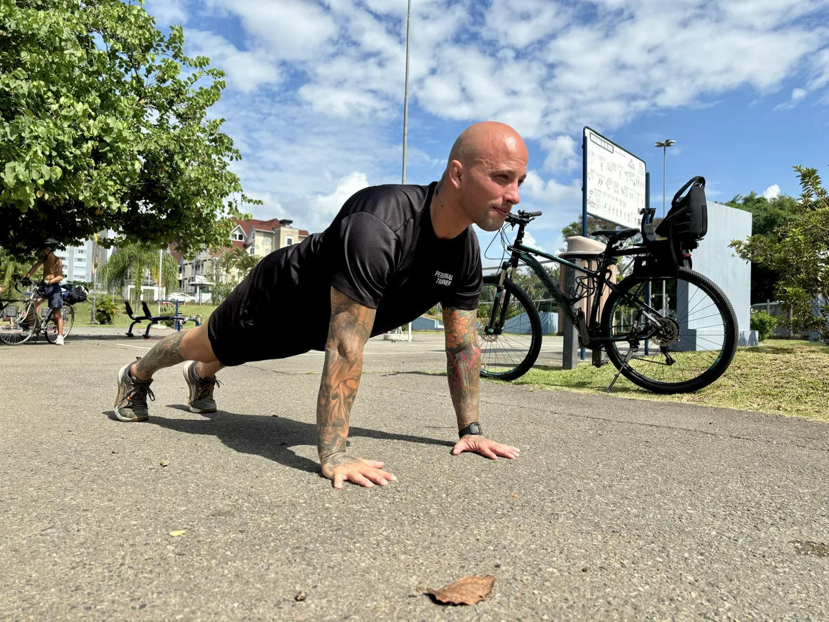 Coach demonstrating a plank outdoors